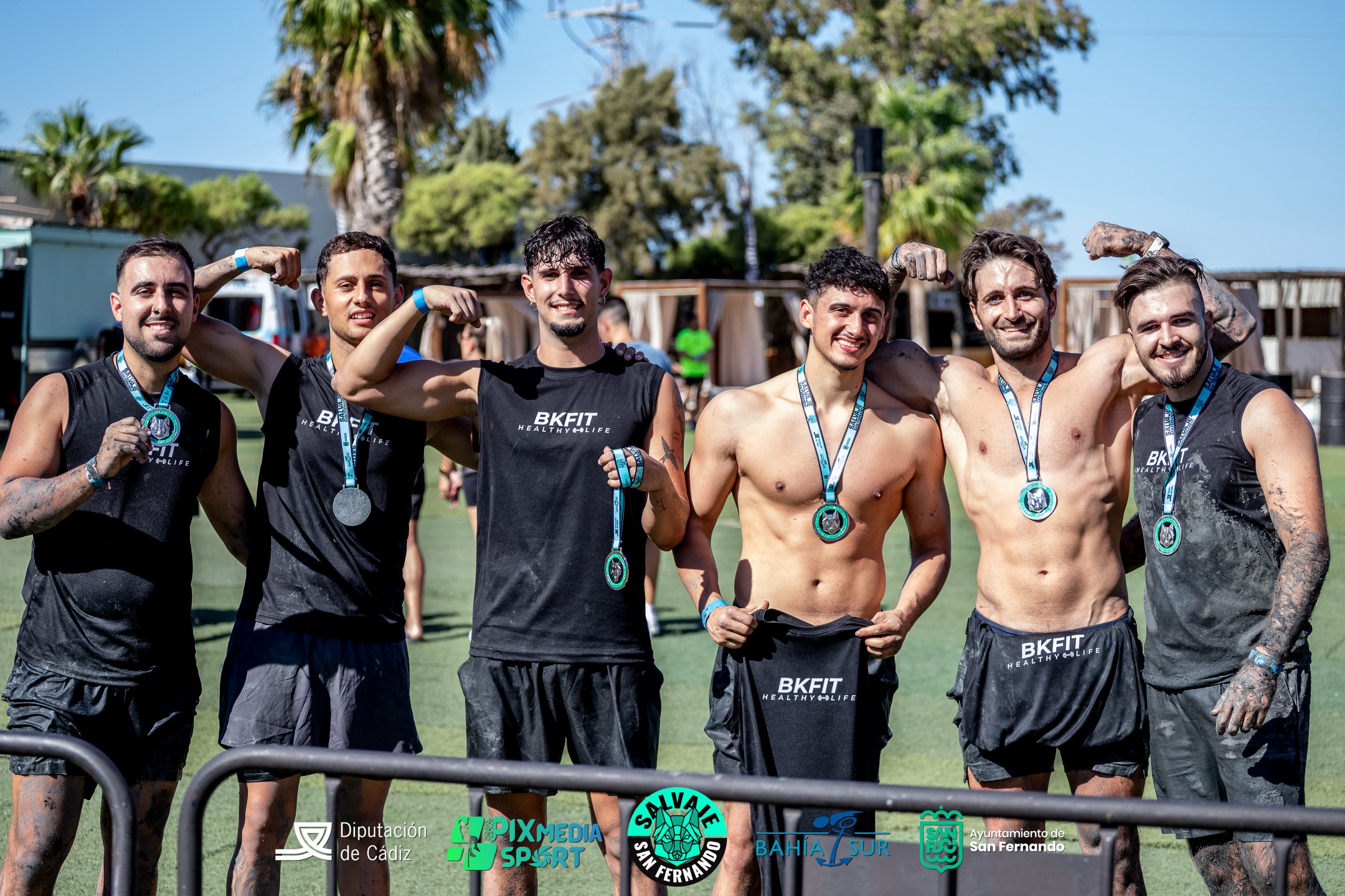 Miembros del equipo BKFIT juntos en una carrera de obstáculos.